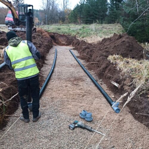 Kanalisatsioonitorude paigaldus metsa alla. Kaugemal seisab roomikekskavaator.
